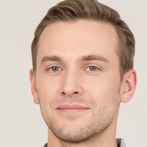 Joyful white young-adult male with short  brown hair and grey eyes