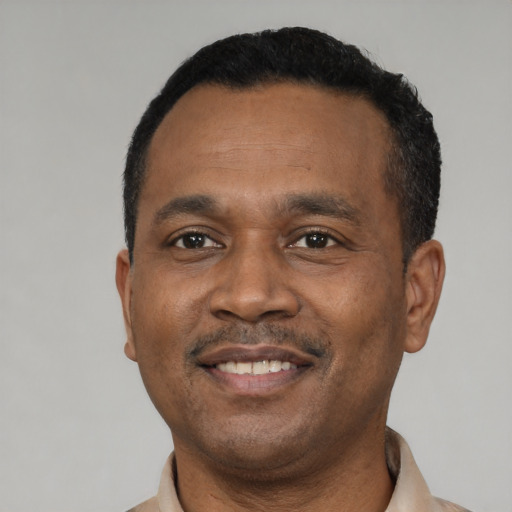 Joyful black young-adult male with short  black hair and brown eyes