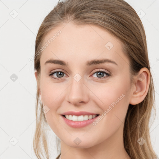 Joyful white young-adult female with long  brown hair and blue eyes