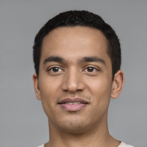 Joyful latino young-adult male with short  black hair and brown eyes