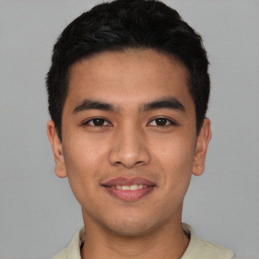 Joyful latino young-adult male with short  black hair and brown eyes