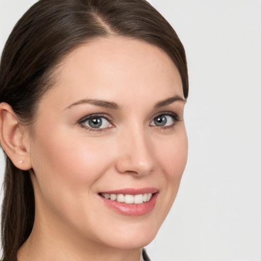 Joyful white young-adult female with medium  brown hair and grey eyes