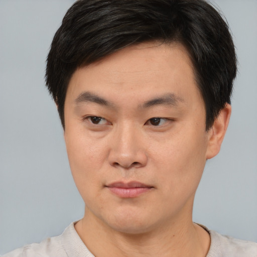 Joyful asian young-adult male with short  brown hair and brown eyes