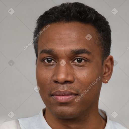 Joyful black young-adult male with short  black hair and brown eyes
