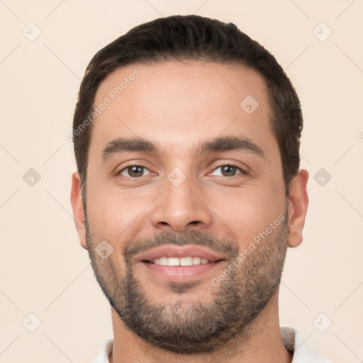 Joyful white young-adult male with short  black hair and brown eyes