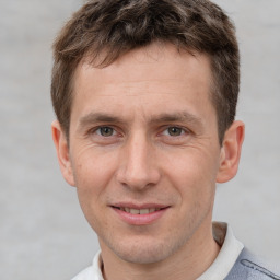 Joyful white adult male with short  brown hair and grey eyes