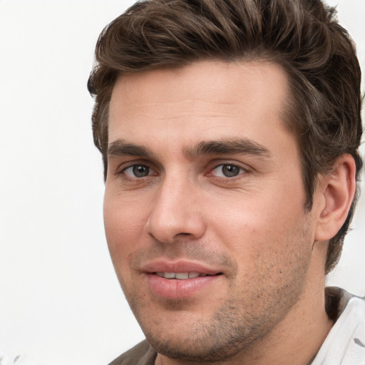 Joyful white young-adult male with short  brown hair and grey eyes