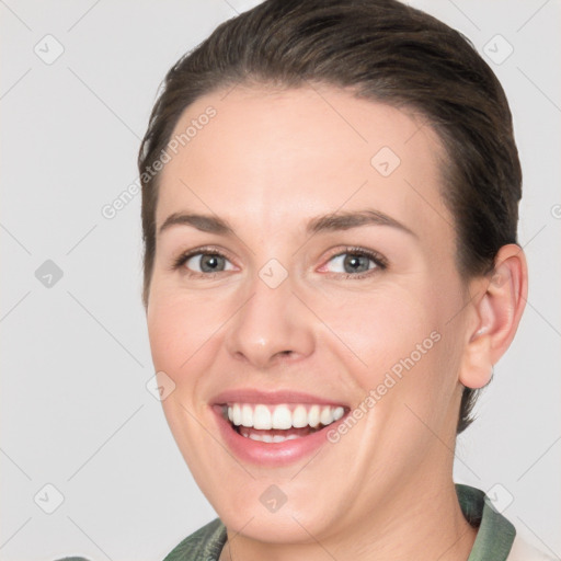 Joyful white young-adult female with medium  brown hair and grey eyes