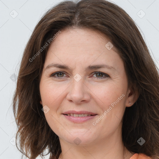 Joyful white adult female with long  brown hair and grey eyes