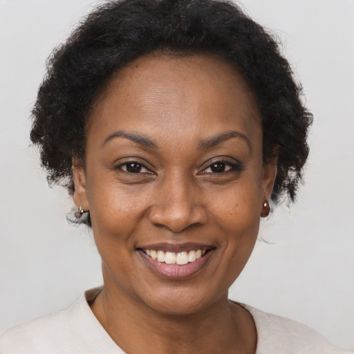 Joyful black adult female with short  brown hair and brown eyes