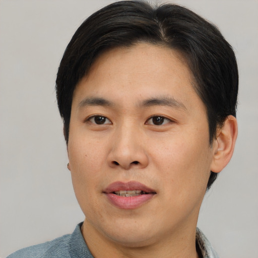 Joyful asian young-adult male with short  brown hair and brown eyes