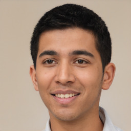 Joyful latino young-adult male with short  black hair and brown eyes