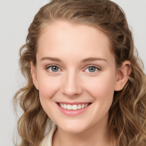 Joyful white young-adult female with long  brown hair and blue eyes