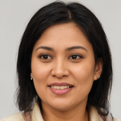 Joyful latino adult female with long  brown hair and brown eyes