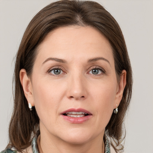 Joyful white adult female with medium  brown hair and grey eyes