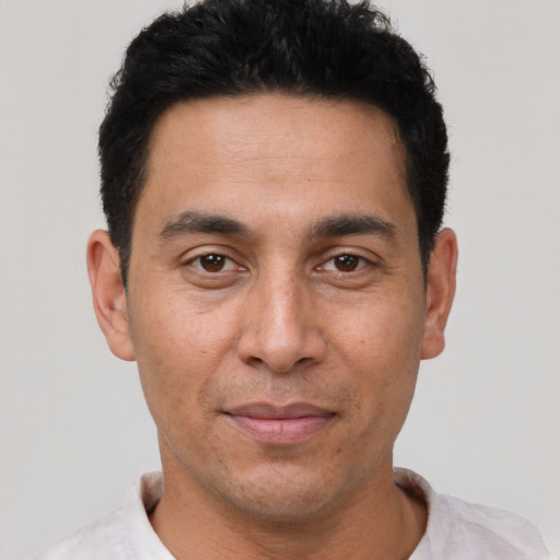 Joyful latino adult male with short  black hair and brown eyes