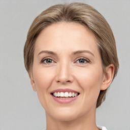 Joyful white young-adult female with medium  brown hair and grey eyes