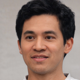 Joyful asian young-adult male with short  black hair and brown eyes