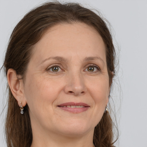 Joyful white adult female with long  brown hair and grey eyes