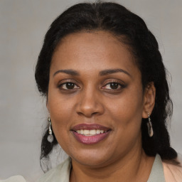 Joyful black adult female with medium  brown hair and brown eyes