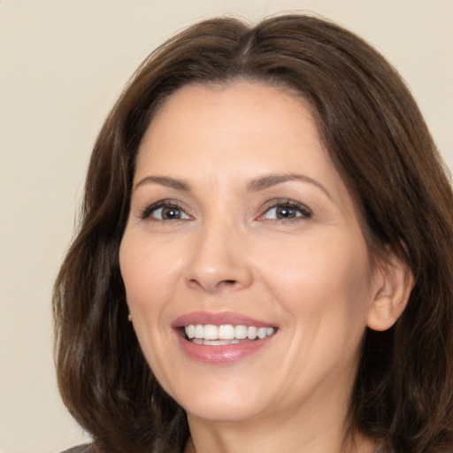 Joyful white adult female with long  brown hair and brown eyes