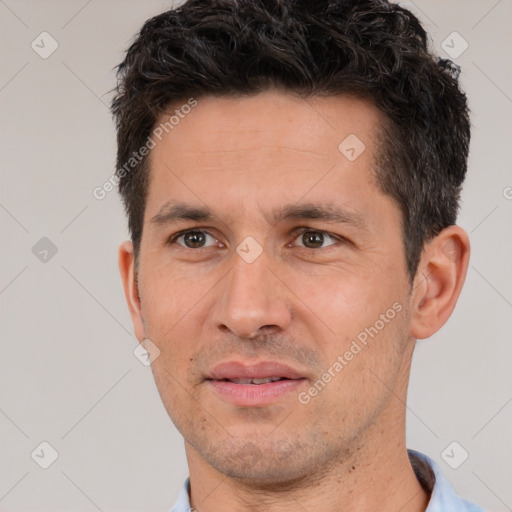 Joyful white adult male with short  black hair and brown eyes