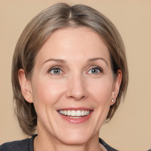 Joyful white adult female with medium  brown hair and grey eyes