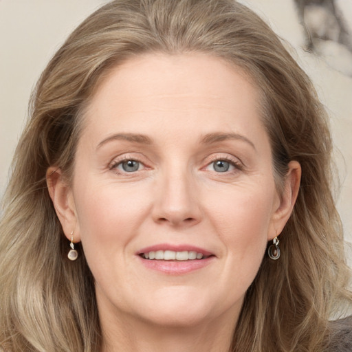 Joyful white adult female with long  brown hair and grey eyes