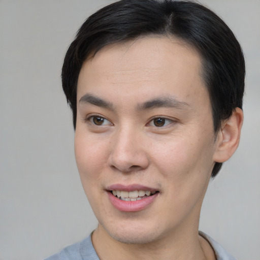 Joyful asian young-adult male with short  brown hair and brown eyes