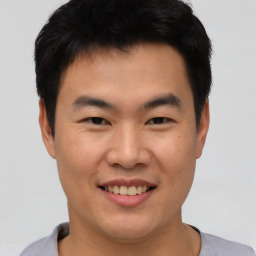 Joyful asian young-adult male with short  black hair and brown eyes