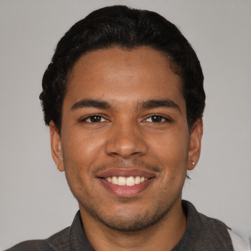 Joyful black young-adult male with short  black hair and brown eyes