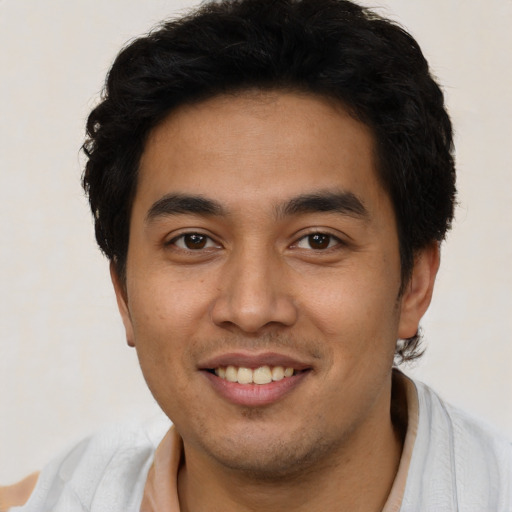 Joyful latino young-adult male with short  black hair and brown eyes