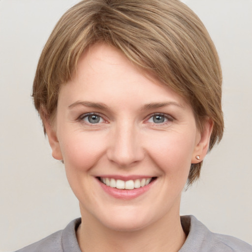 Joyful white young-adult female with short  brown hair and grey eyes