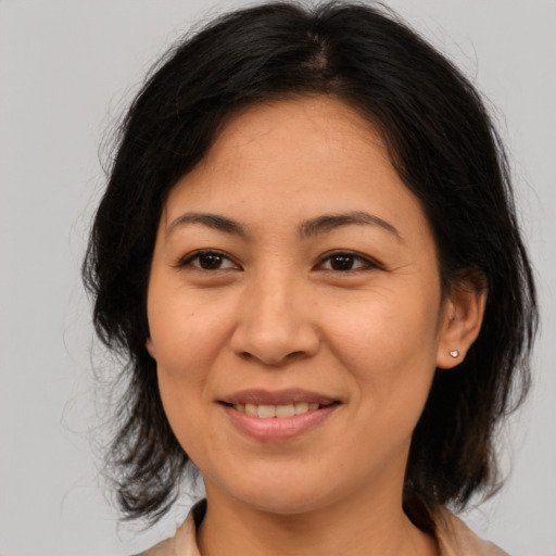 Joyful asian adult female with medium  brown hair and brown eyes
