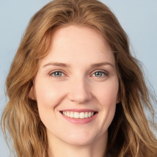 Joyful white young-adult female with long  brown hair and blue eyes