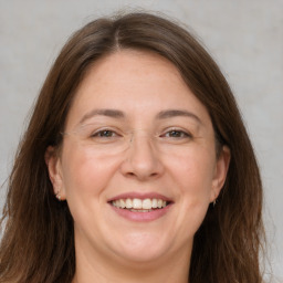 Joyful white adult female with long  brown hair and grey eyes