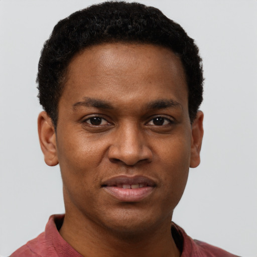 Joyful black young-adult male with short  brown hair and brown eyes
