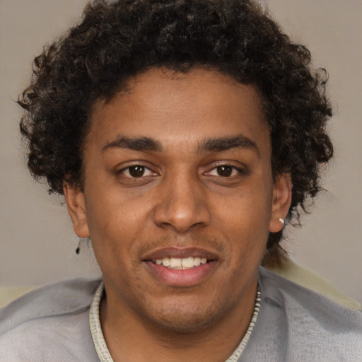 Joyful black young-adult male with short  brown hair and brown eyes