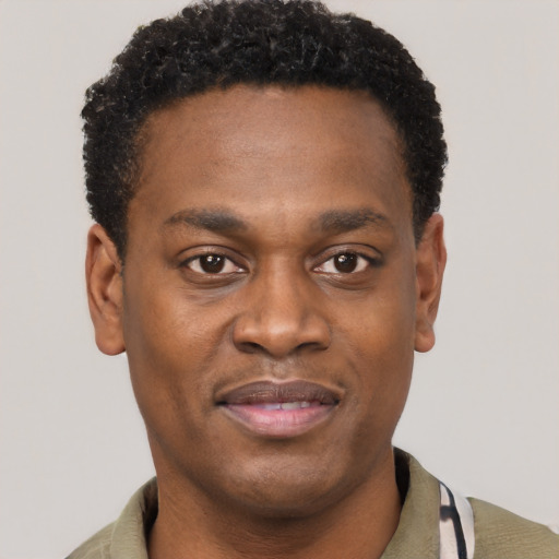 Joyful black young-adult male with short  black hair and brown eyes