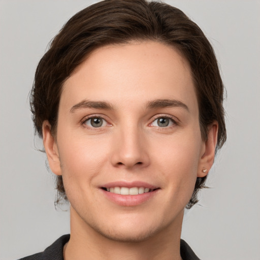 Joyful white young-adult female with short  brown hair and grey eyes