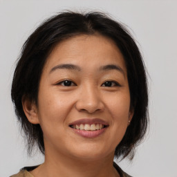 Joyful asian young-adult female with medium  brown hair and brown eyes