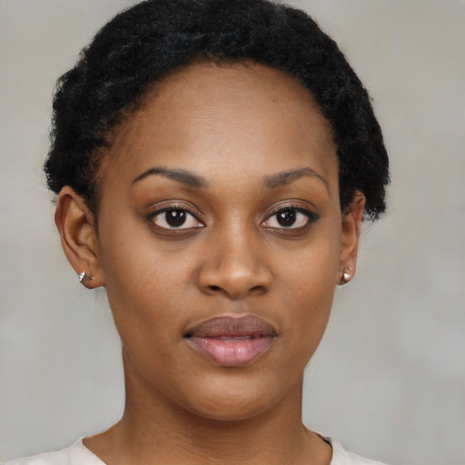 Joyful black young-adult female with short  black hair and brown eyes