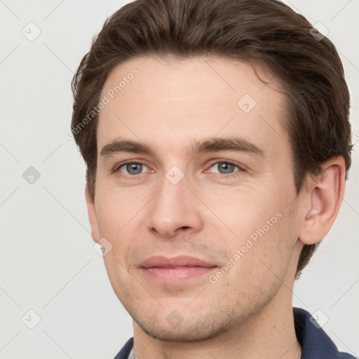 Joyful white young-adult male with short  brown hair and grey eyes