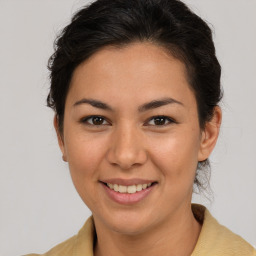 Joyful latino young-adult female with medium  brown hair and brown eyes