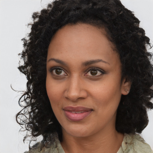 Joyful black young-adult female with long  brown hair and brown eyes