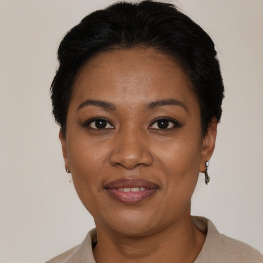 Joyful black young-adult female with short  black hair and brown eyes