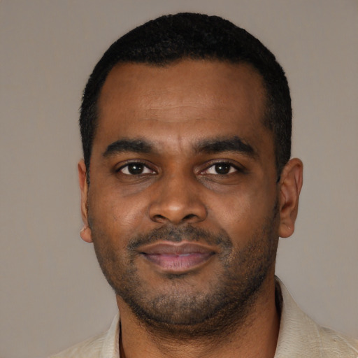 Joyful black young-adult male with short  black hair and brown eyes