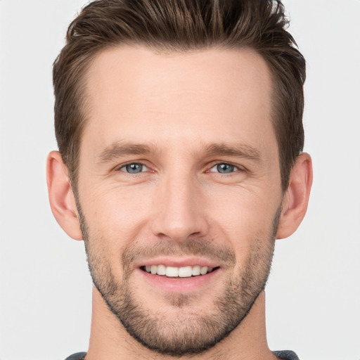 Joyful white young-adult male with short  brown hair and grey eyes