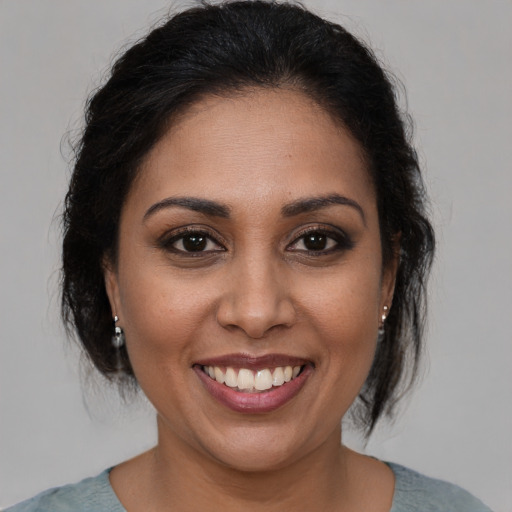 Joyful latino young-adult female with medium  brown hair and brown eyes