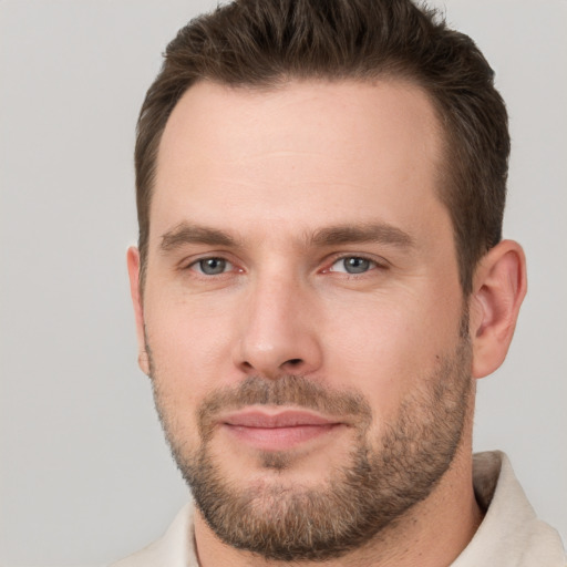 Joyful white young-adult male with short  brown hair and grey eyes